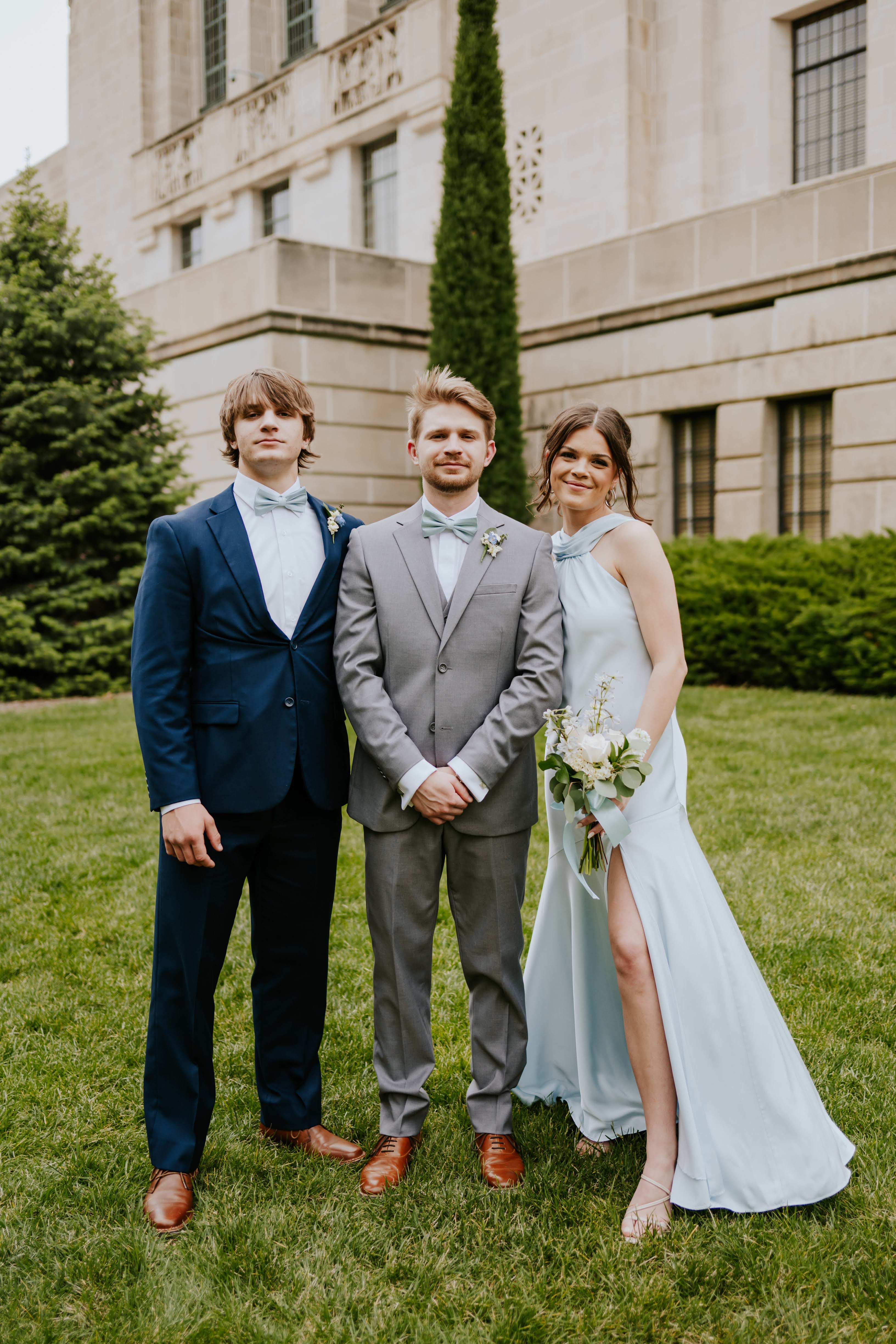 Jude standing with his sister and brother at the wedding.