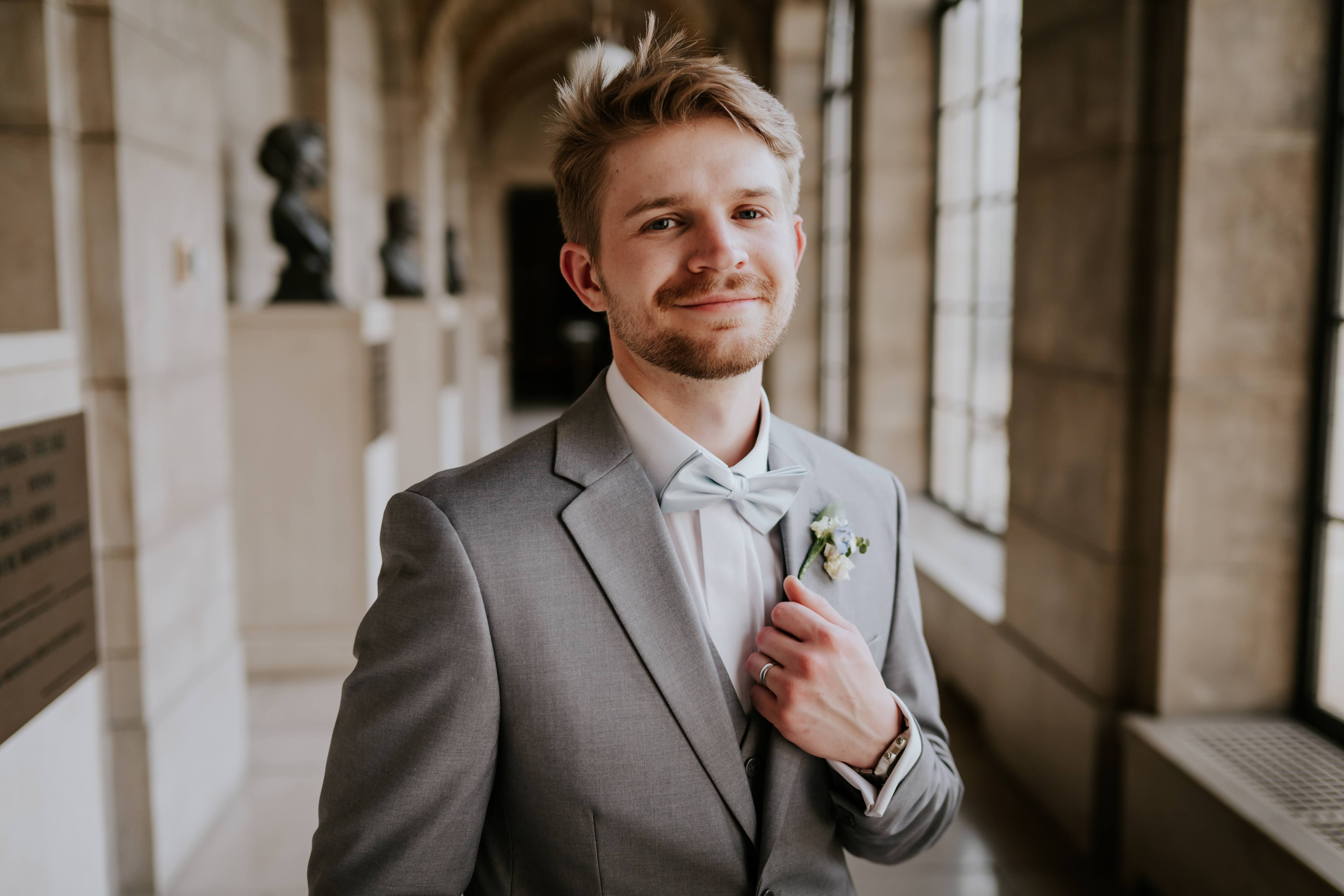 Jude smiling in a gray suit on his wedding day.